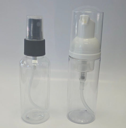 Two bottles, one is a clear plastic spray bottle with black cap and the other is a clear plastic foaming pump bottle with a white pump on a light gray background